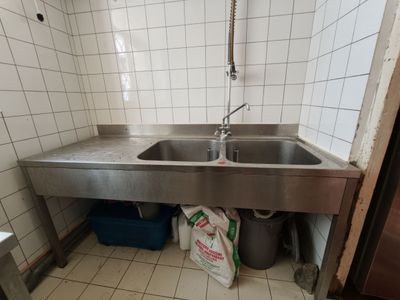 un évier en acier inoxydable dans le coin d'une salle de bains