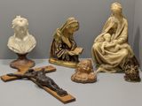 quatre statues de Jésus et une femme assise sur une croix
