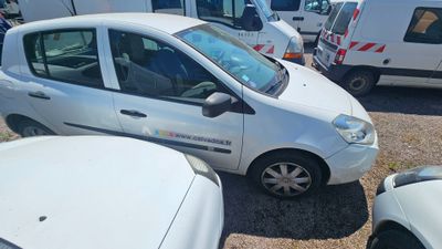 a small white car that is parked in a parking lot