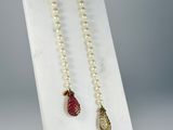 a close up of a necklace on a display stand with pearls