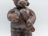a wooden statue of a bear holding a piece of wood