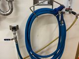 un tuyau bleu fixé au mur à côté d'un évier