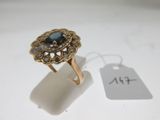l'image d'une bague en or ornée d'une pierre bleue