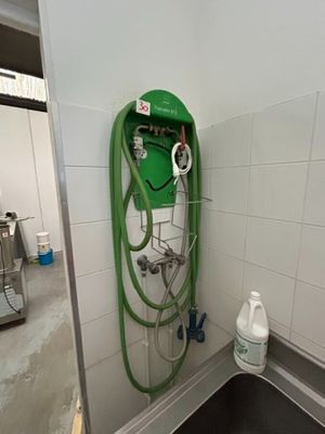 un tuyau vert fixé au mur d'une salle de bains