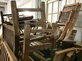 a pile of wooden chairs sitting in a room
