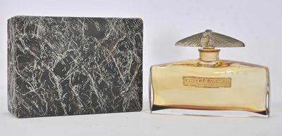 l'image d'un flacon de parfum posé à côté d'une boîte