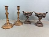 Trois bougeoirs en laiton ancien sont posés sur une table