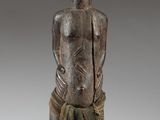 an image of a wooden statue of a man with his hands in his pockets