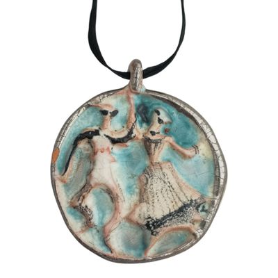 une photo d'un pendentif sur lequel figurent un homme et une femme en train de danser