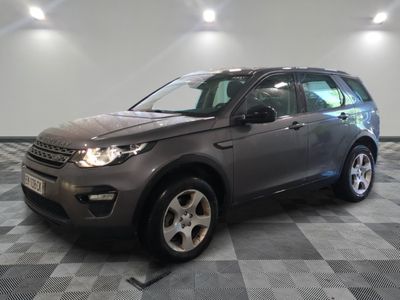La Land Rover grise est garée dans une grande pièce au sol carrelé en damier.