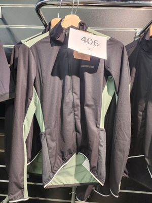 trois vestes suspendues à un portant dans un magasin