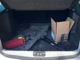 the trunk of a car with a box and luggage in it