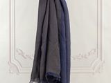 the blue scarf is hanging on a clothes line in front of a white wall