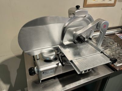 une photo d'une trancheuse à viande posée sur un plan de travail