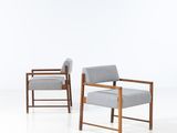 two chairs in a room with a white floor and a white wall