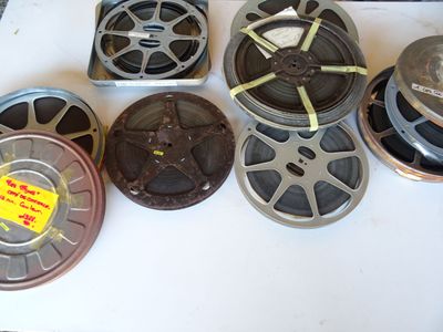 de nombreuses bobines de films anciens posées sur une table