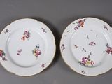 two plates with flowers on them are sitting on a table