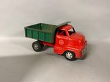 a red toy truck with a green trailer on a white surface