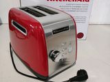 a red toaster sitting on a counter next to a box of kitchen aid
