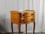 une petite table en bois avec deux tiroirs