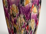 a purple vase with gold and black designs on it