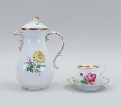 a white and gold coffee pot with a cup and saucer