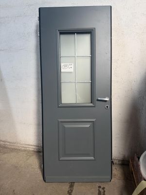 une porte grise avec une vitre dans une pièce