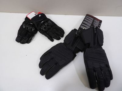 two pairs of black gloves sitting on top of a white table