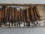 a box with a bunch of wood chisels in it