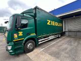 a large green truck parked in front of a building
