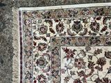 un tapis posé à même le sol, sur lequel est allongé un chat