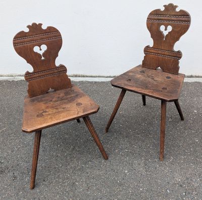pair of antique wooden chairs with hearts on the back of them