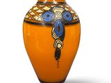 an orange vase with a blue and yellow design on it