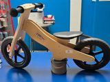 un petit vélo en bois posé sur une table bleue dans un magasin