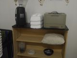une petite étagère sur laquelle sont posés une cafetière et d'autres objets