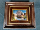 framed picture of a painting of a house and a river
