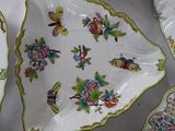 many plates and bowls on a table with a white table cloth