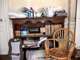 an image of a cluttered room with a chair and bookshelf