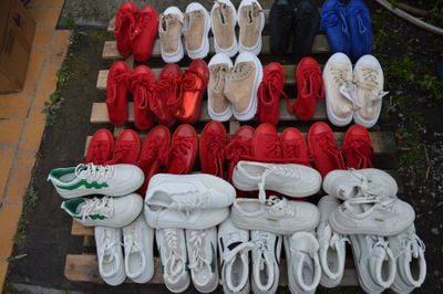 de nombreuses paires de chaussures empilées sur une palette