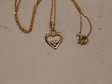 a couple of gold necklaces with diamonds on them on a table