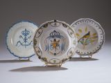 three plates with designs on them sitting on a white surface