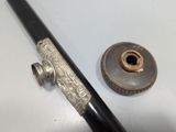 a metal pipe and a metal pipe holder on a table