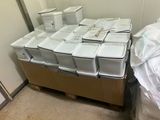 a pile of boxes and containers sitting on a pallet in a room
