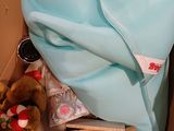 a teddy bear in a box with a blanket on it