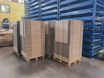 several pallets of cardboard are stacked on pallets in a warehouse