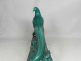 green ceramic bird figurine sitting on top of a green base