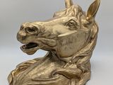 brass statue of a horse ' s head on a white background