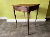a small wooden table with a drawer on top of it