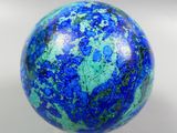 a blue and green marble ball on a white surface