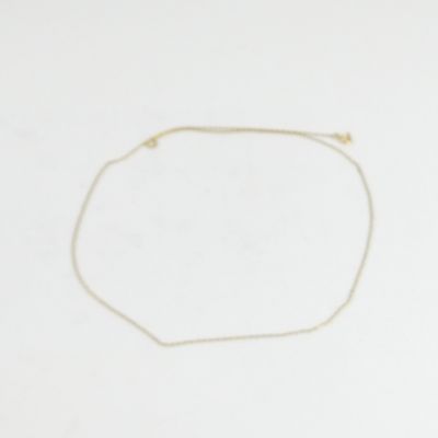 un bracelet en chaîne d'or orné d'une perle dorée sur fond blanc